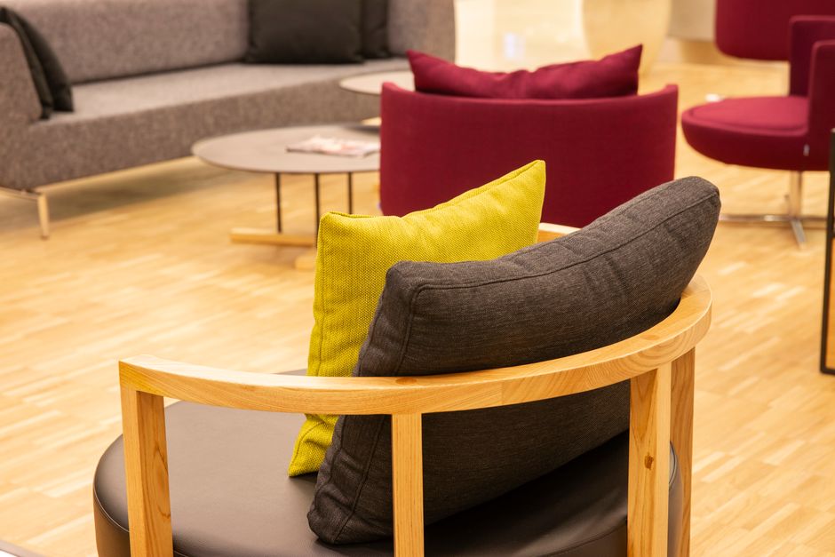 Cozy office lounge area showcasing modern armchairs with throw pillows.